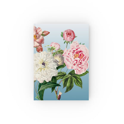 Floral design Notebook on a blue background with pink, white, and green flowers.